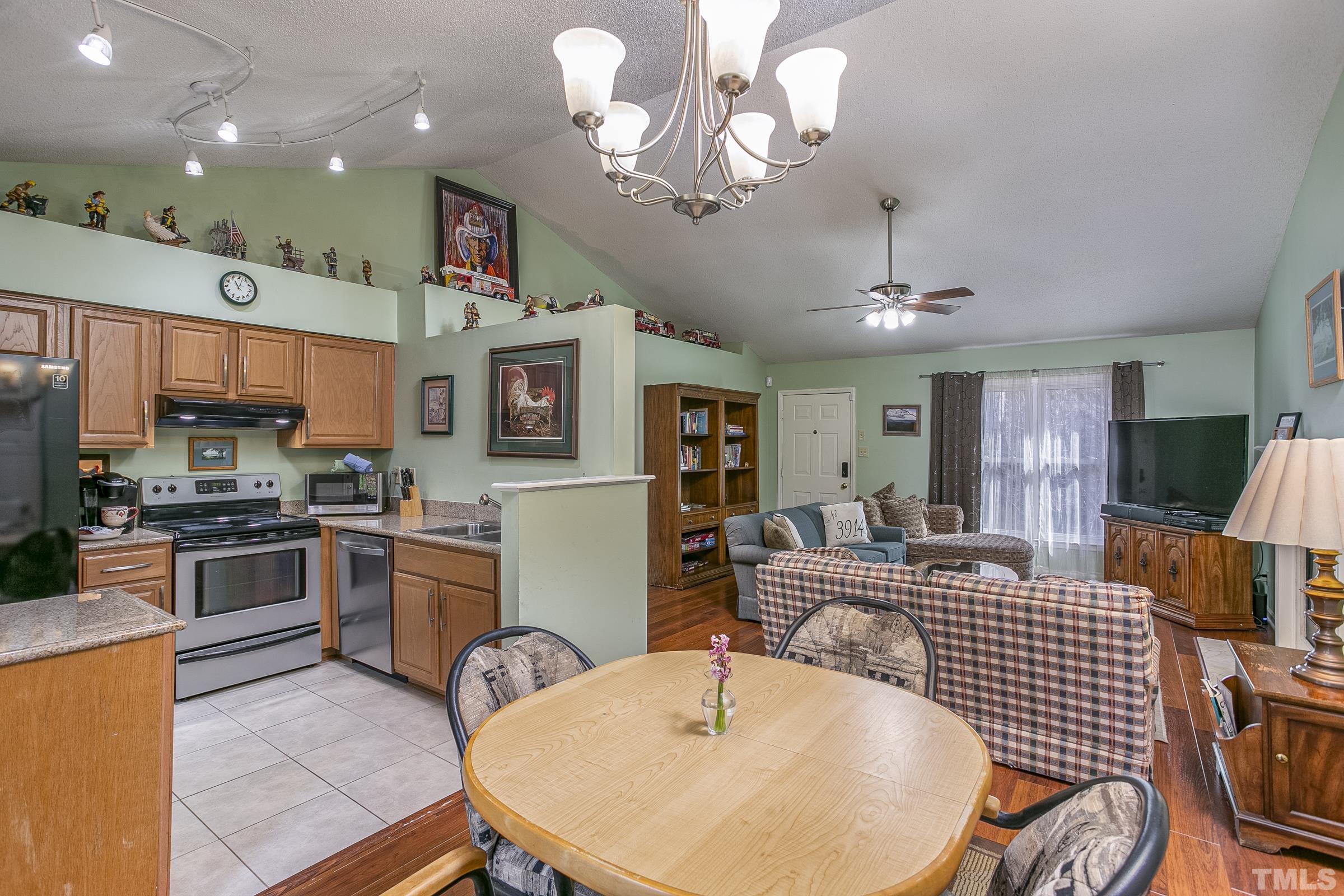 3914 Olde Coach Road Durham, NC 27707 - Photo 8 of 22 a kitchen with stainless steel appliances granite countertop a stove top oven a sink dishwasher a dining table and chairs with wooden floor