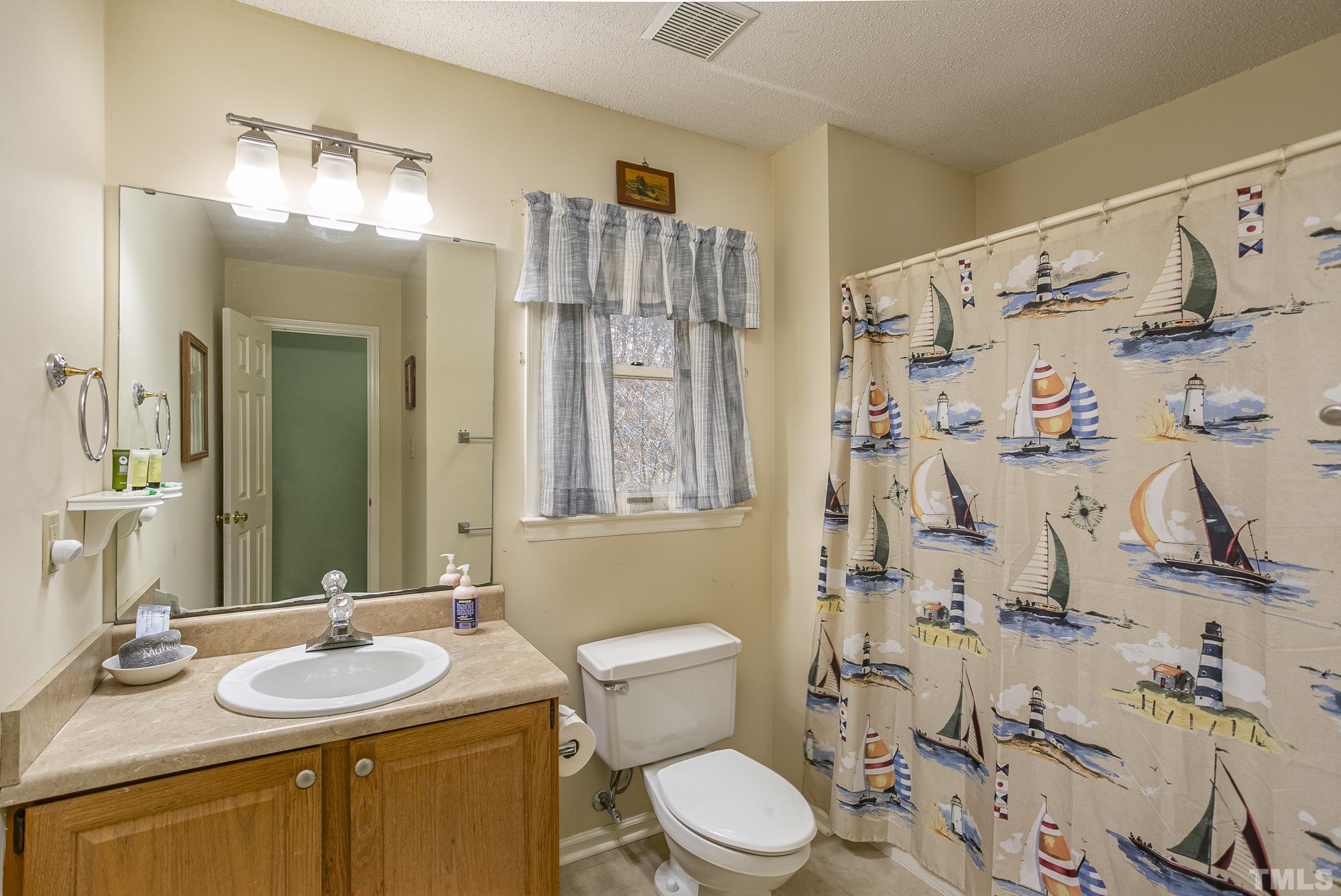 3914 Olde Coach Road Durham, NC 27707 - Photo 10 of 22 a bathroom with a granite countertop sink toilet and shower