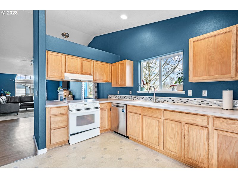 1528 Briar Road Independence, OR 97351 - Photo 7 of 25 a kitchen with stainless steel appliances granite countertop a stove a sink and white cabinets with wooden floor
