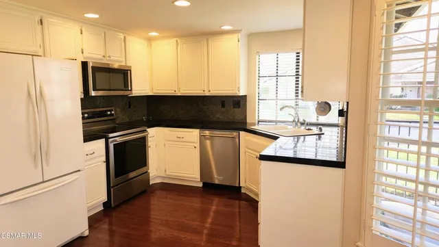 a kitchen with stainless steel appliances granite countertop a stove a sink and a refrigerator