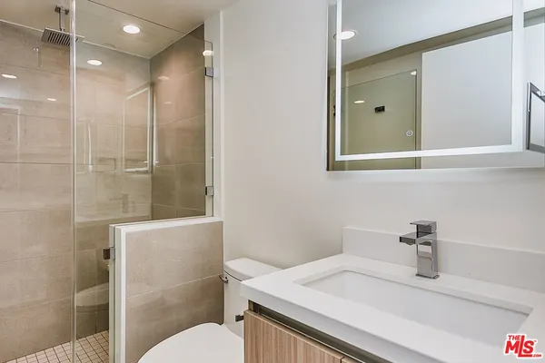 a bathroom with a sink vanity granite toilet and a mirror