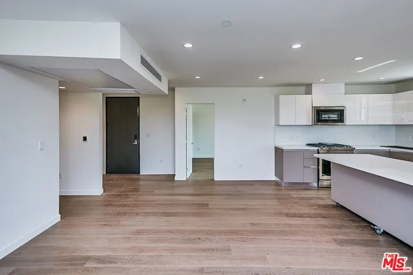 a view of kitchen with stainless steel appliances granite countertop a stove and a refrigerator