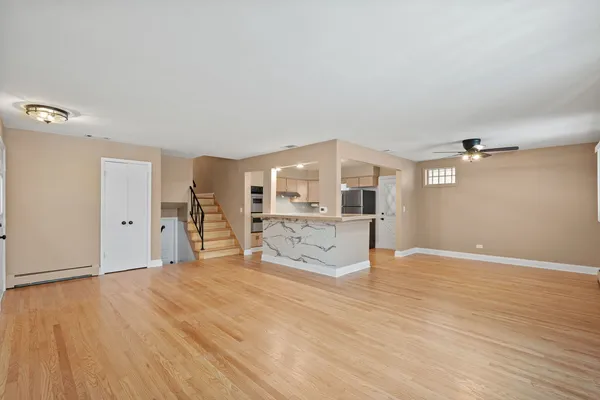 a view of a big room with wooden floor and windows
