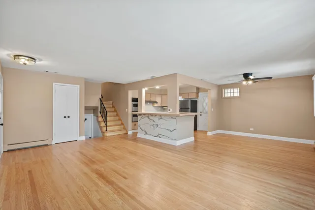 a view of a big room with wooden floor and windows