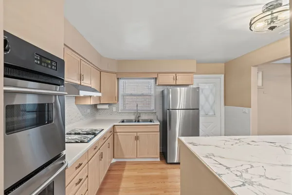 a kitchen with a sink a refrigerator and a stove top oven