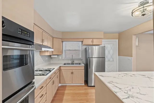 a kitchen with a sink a refrigerator and a stove top oven