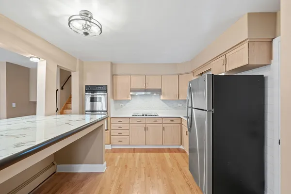 a kitchen with stainless steel appliances granite countertop a refrigerator a stove and a sink