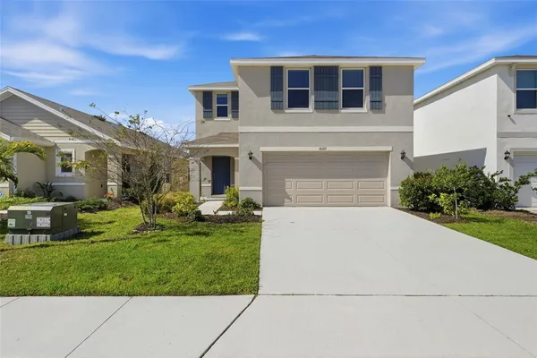 a front view of a house with a yard and garage