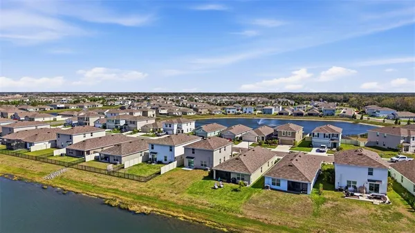 an aerial view of residential houses with outdoor space and ocean view