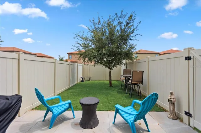 a view of a chair and table in backyard of the house