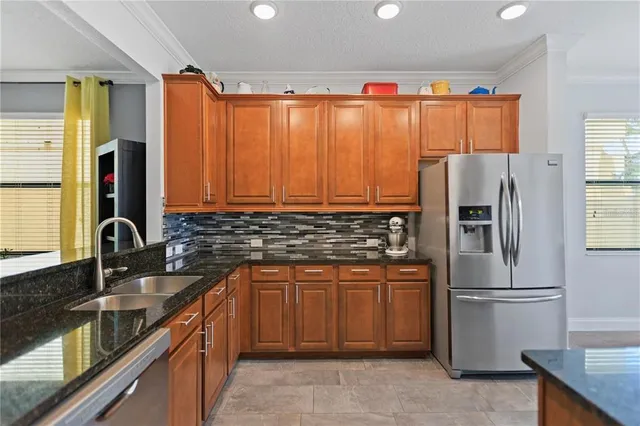 a kitchen with stainless steel appliances granite countertop a refrigerator and a sink
