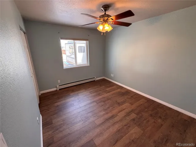 an empty room with a window and a fan