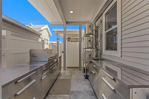 a large kitchen with stainless steel appliances a large counter top a stove and a wooden floors