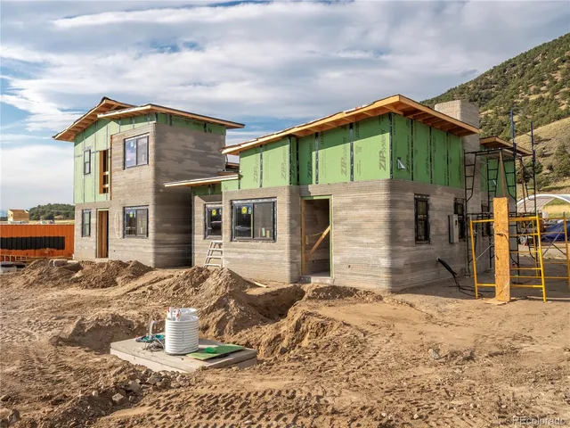 a front view of a house with a yard and seating space