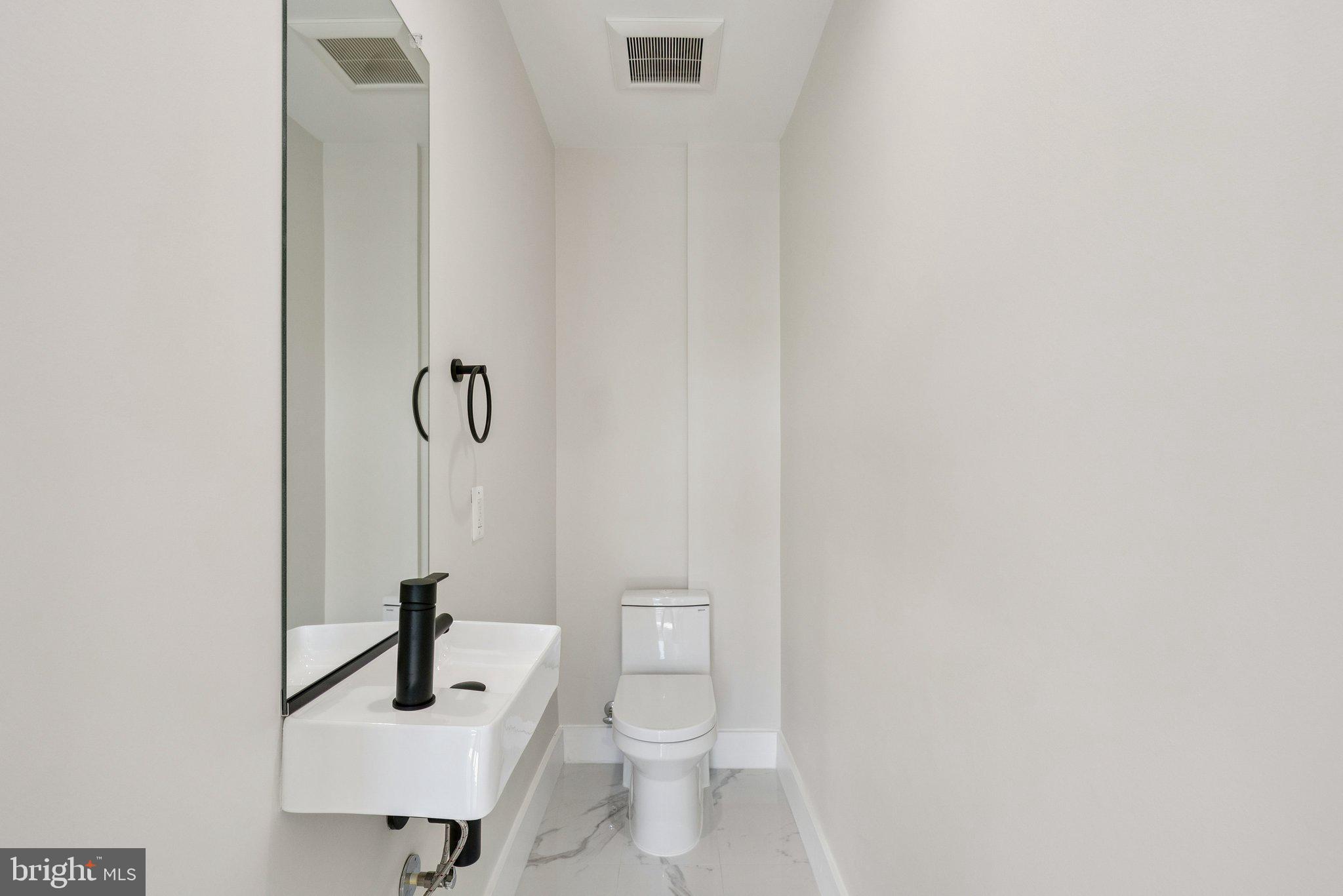 2134 Wisconsin Avenue Northwest, Unit 6 Washington, DC 20007 - Photo 14 of 40 a bathroom with a toilet a sink and a mirror