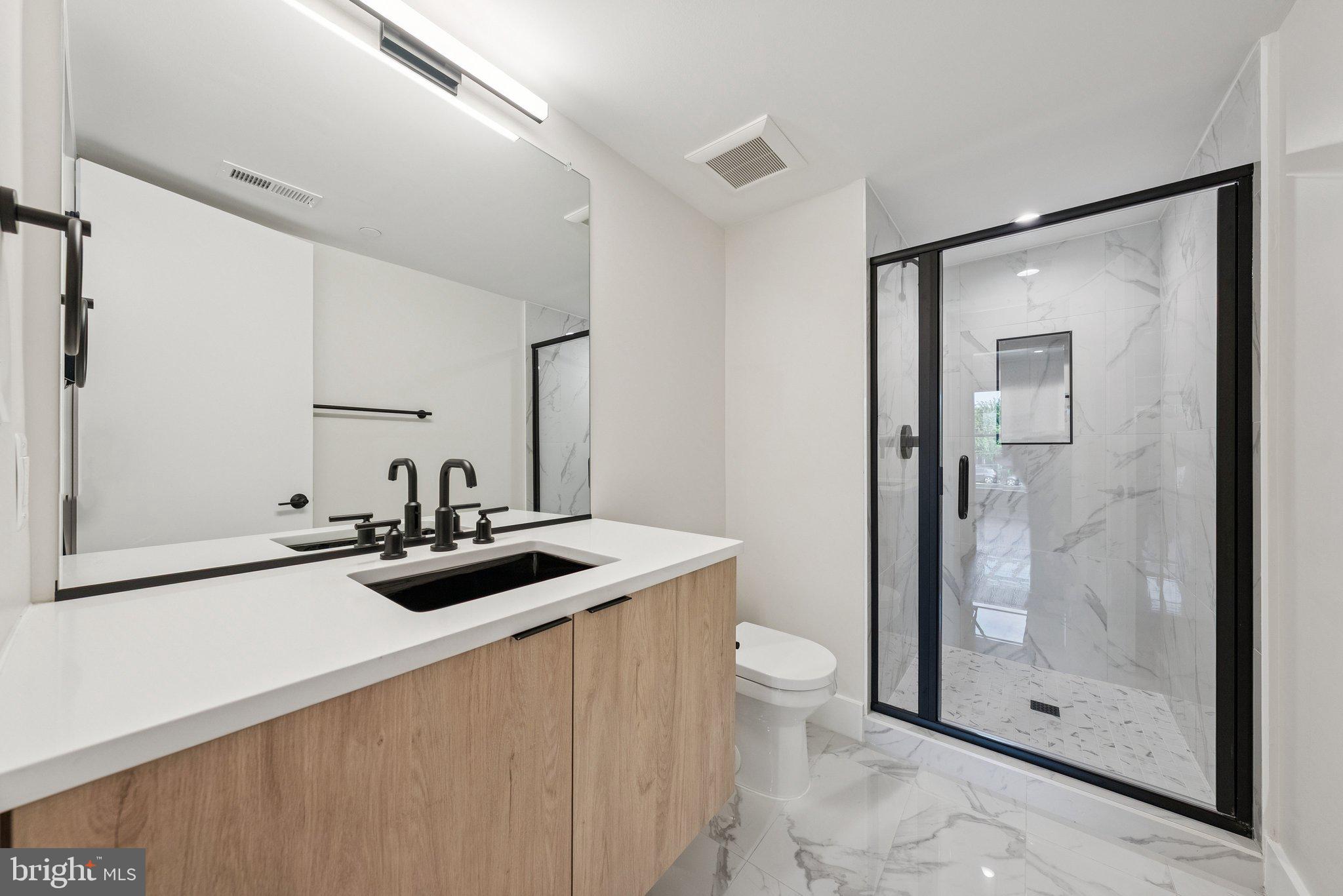 2134 Wisconsin Avenue Northwest, Unit 6 Washington, DC 20007 - Photo 15 of 40 a bathroom with a sink a toilet and shower