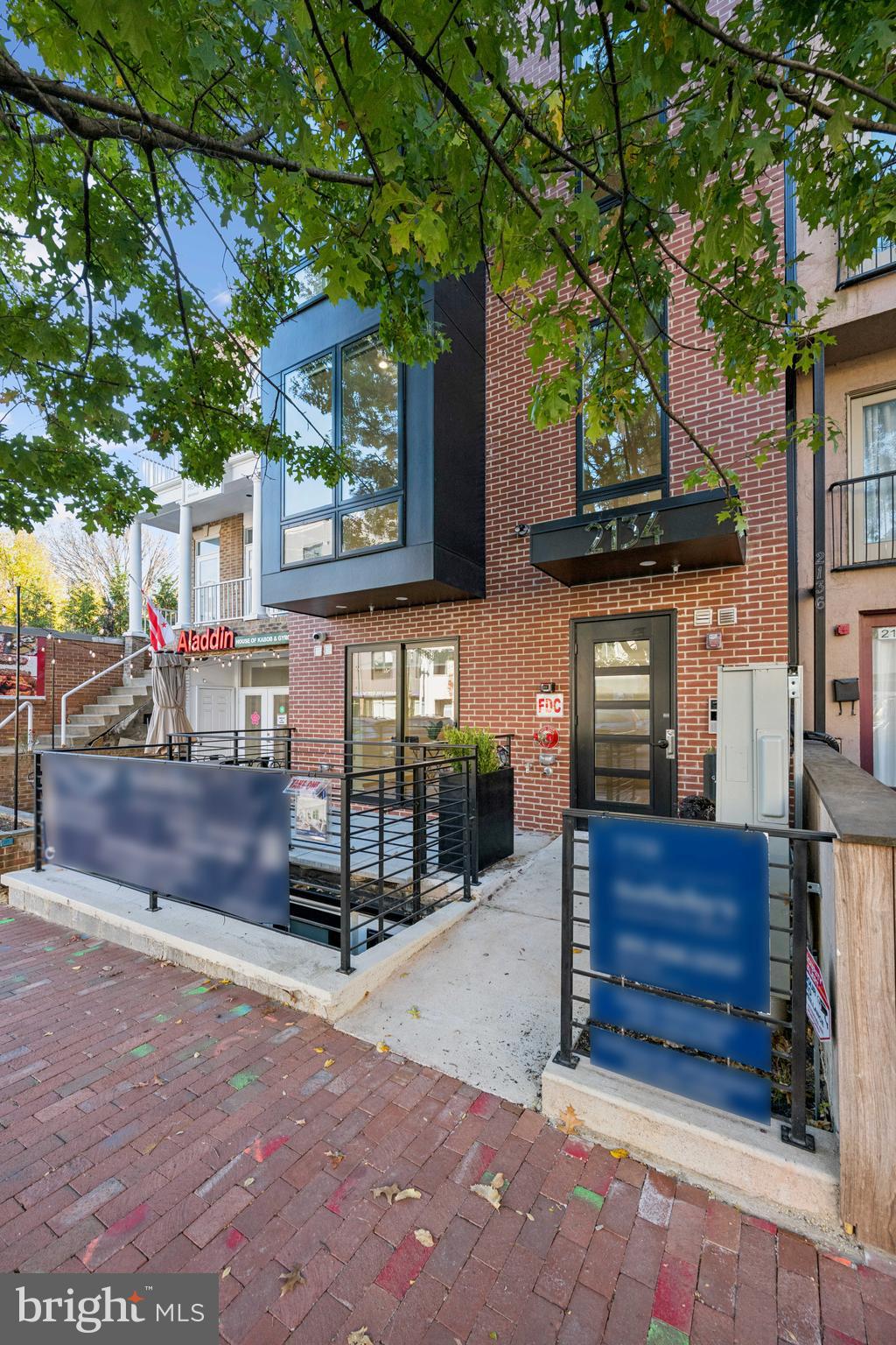 2134 Wisconsin Avenue Northwest, Unit 6 Washington, DC 20007 - Photo 38 of 43 a view of a brick house with many windows next to a road