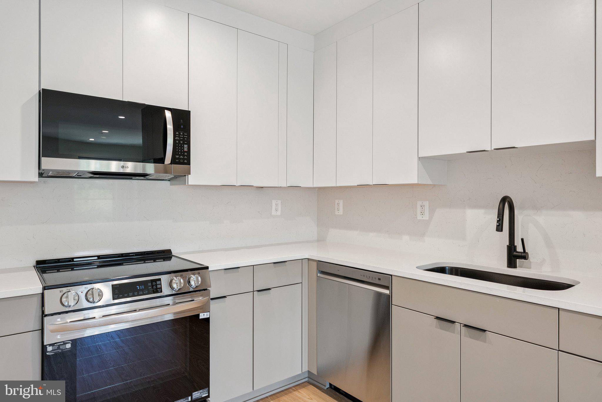 2134 Wisconsin Avenue Northwest, Unit 6 Washington, DC 20007 - Photo 7 of 40 a kitchen with white cabinets stainless steel appliances and sink