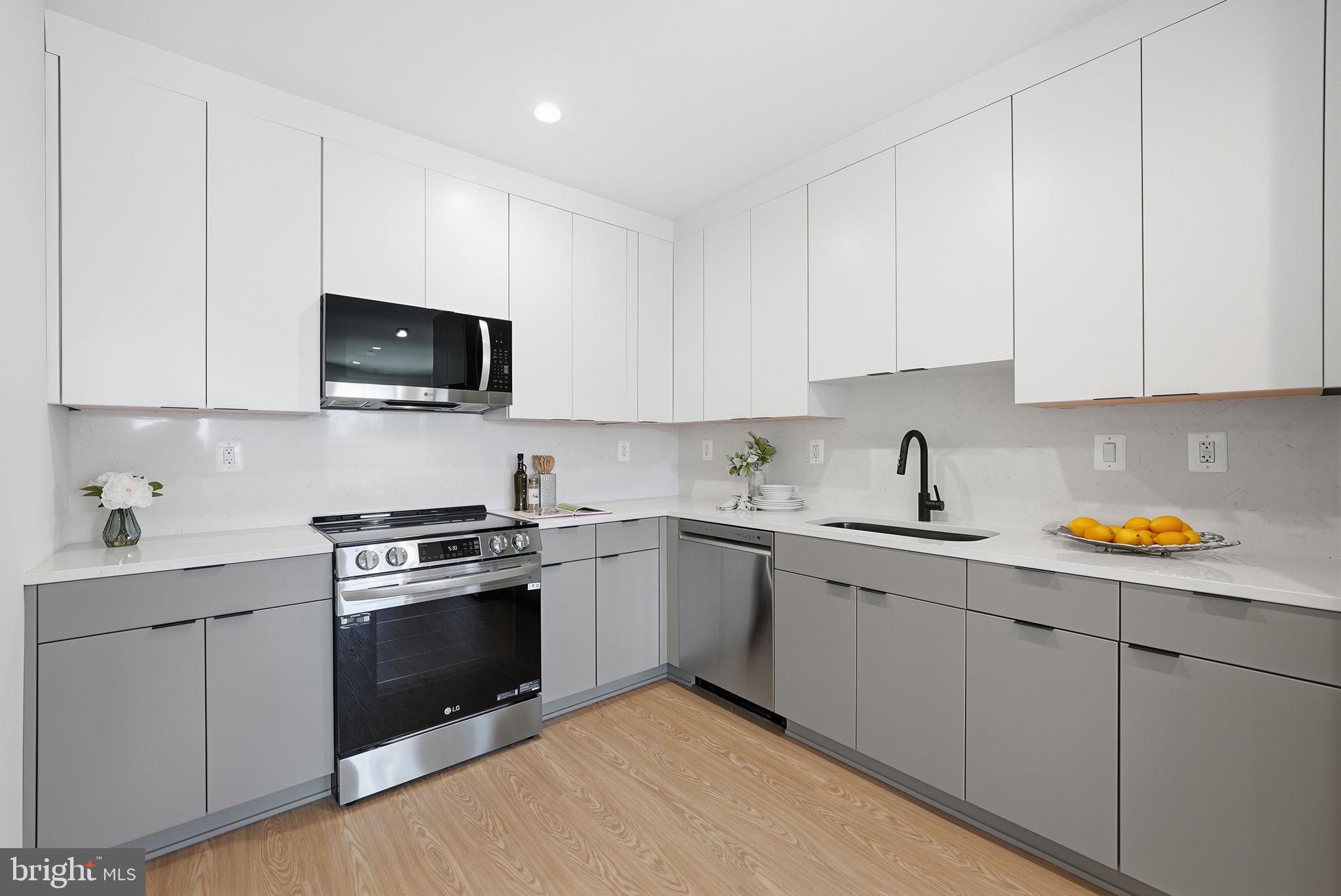 2134 Wisconsin Avenue Northwest, Unit 6 Washington, DC 20007 - Photo 8 of 43 a kitchen with stainless steel appliances granite countertop a sink and dishwasher a stove top oven with white countertops