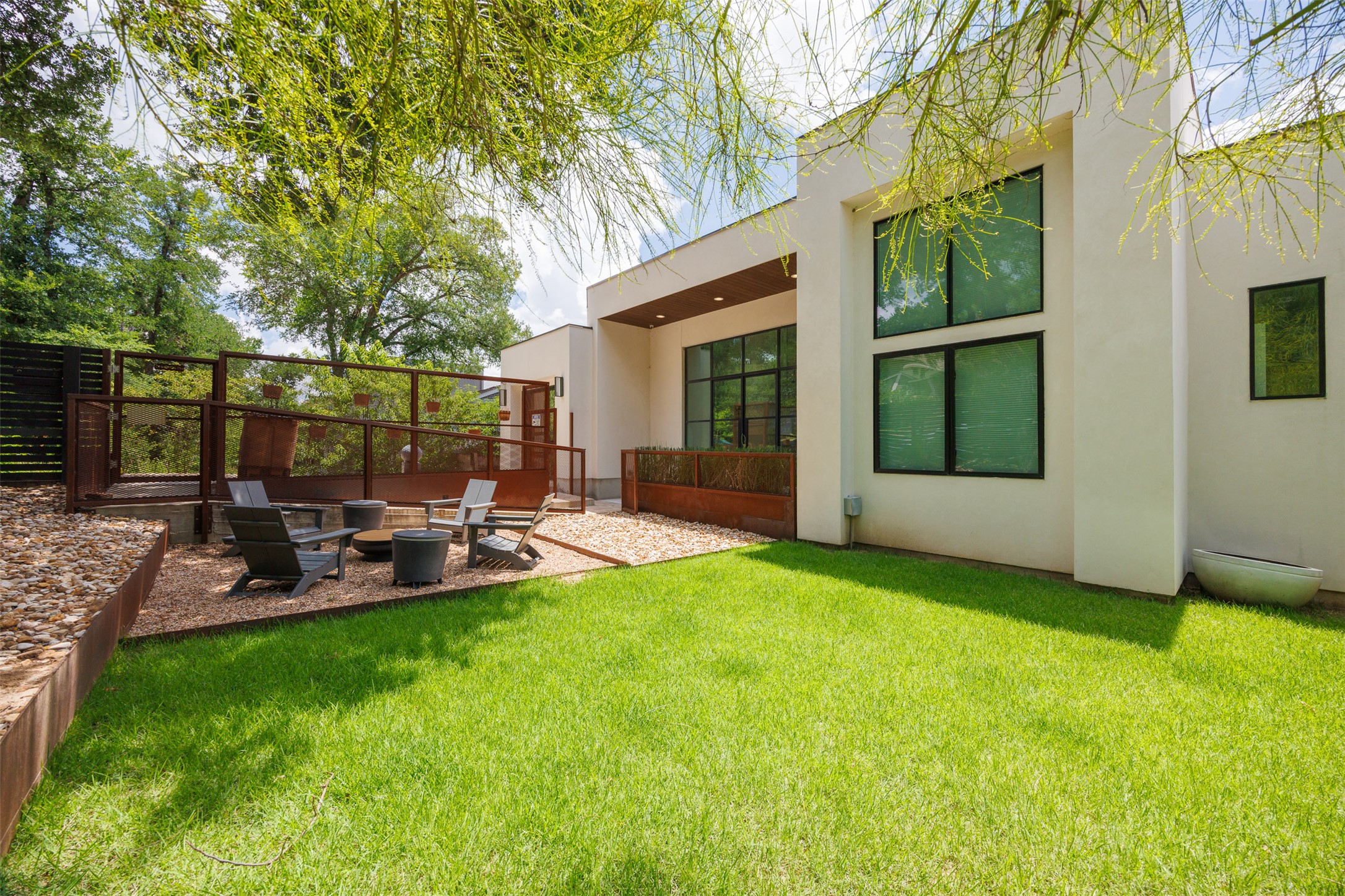 4103 Ridgelea Drive Austin, TX 78731 - Photo 1 of 26 A private courtyard oasis features vibrant green grass and a gravel patio, perfect for relaxing.