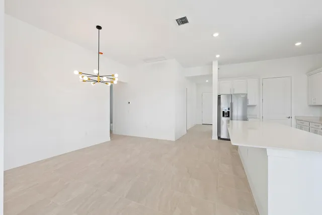 a view of kitchen with kitchen island white cabinets and stainless steel appliances