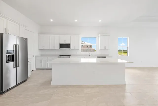 a large kitchen with stainless steel appliances a stove a sink dishwasher and a refrigerator