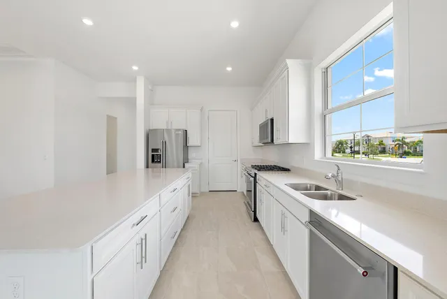 a view of a kitchen with a refrigerator and a sink