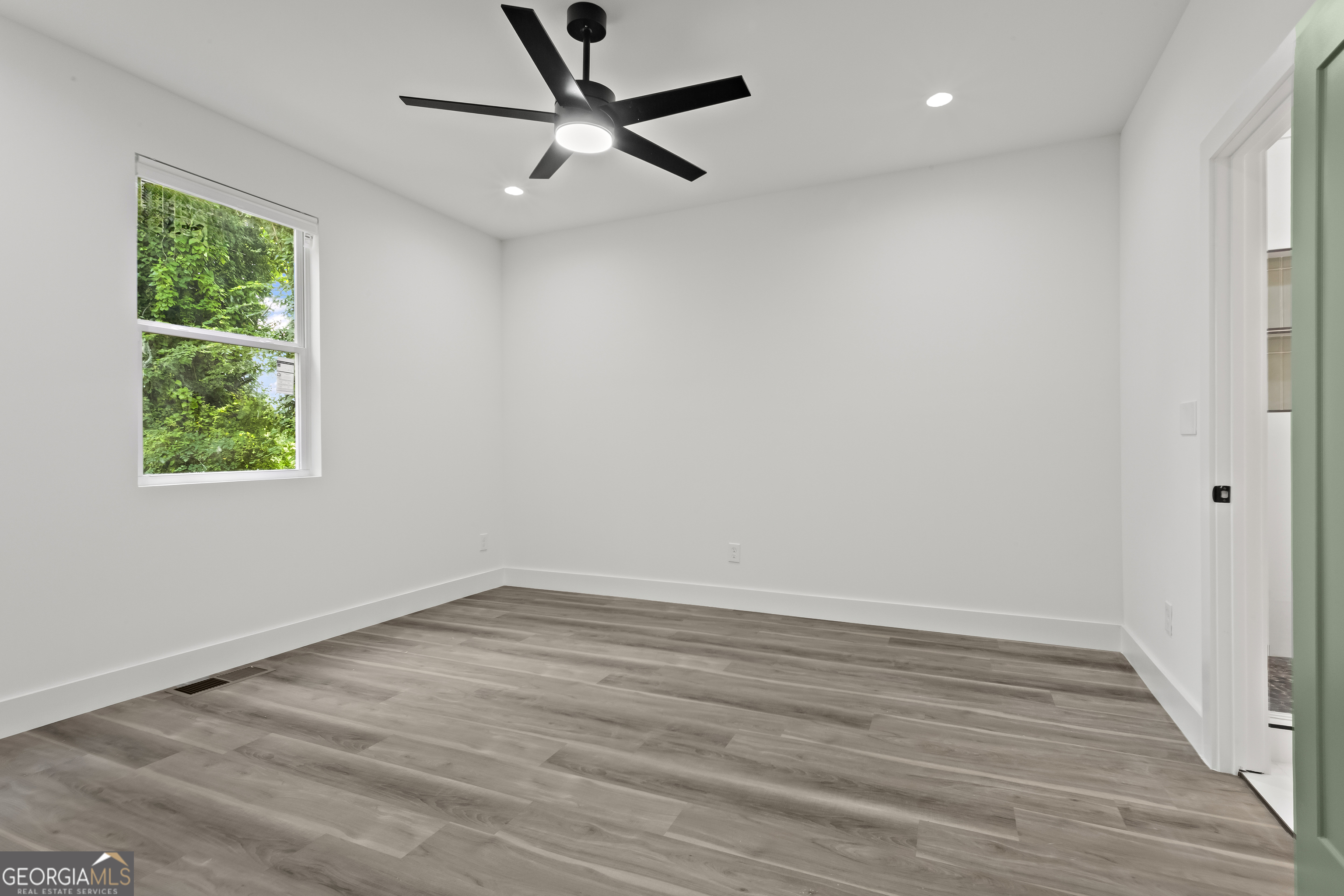 598 Formwalt Street Southwest Atlanta, GA 30312 - Photo 13 of 23 an empty room with wooden floor ceiling fan and windows