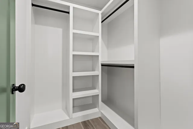 a view of walk in closet with empty racks