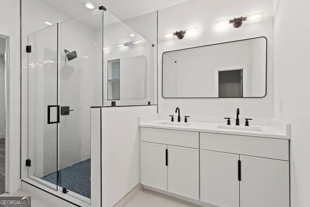 a bathroom with a shower sink and mirror