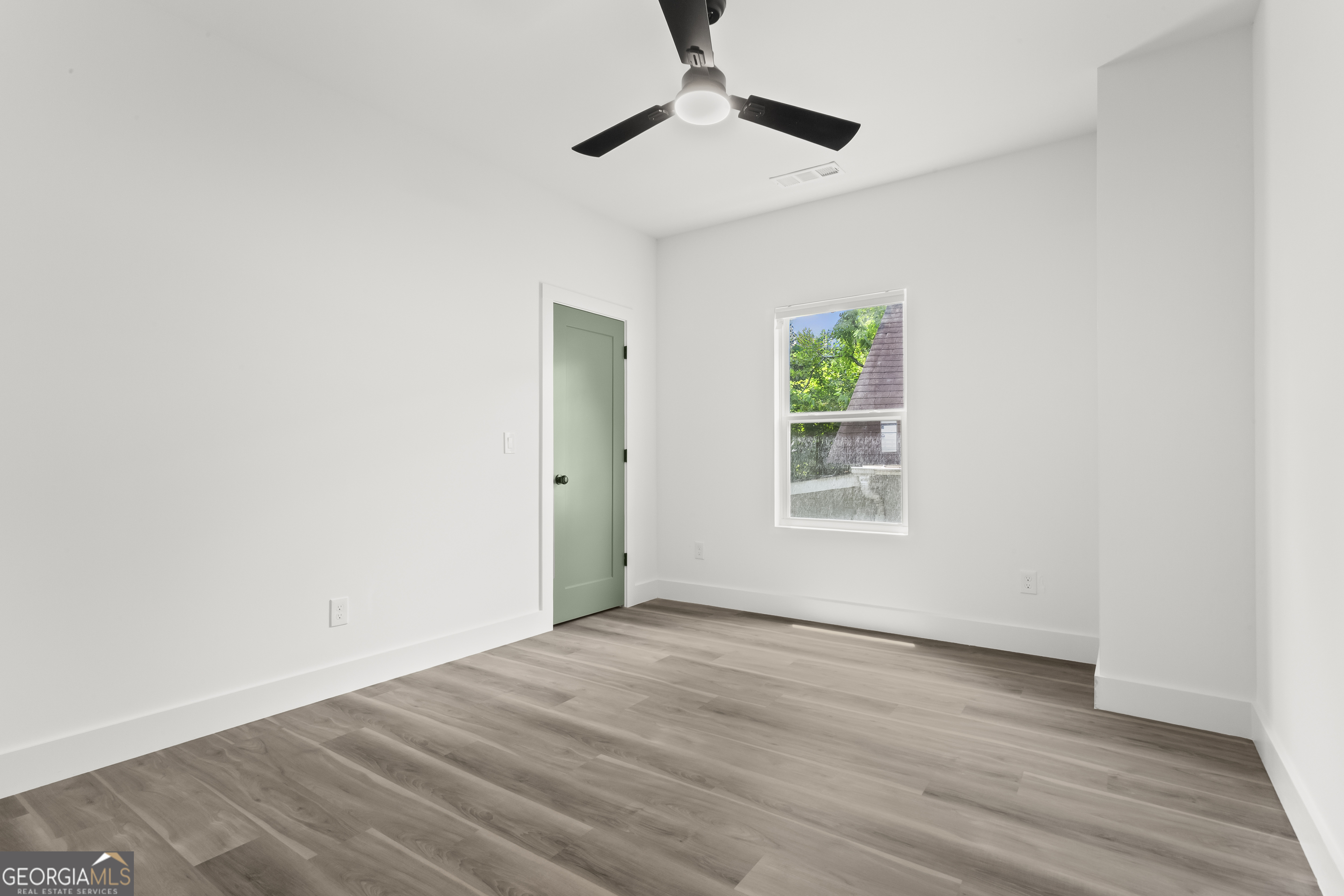598 Formwalt Street Southwest Atlanta, GA 30312 - Photo 18 of 23 a view of an empty room with wooden floor and a window