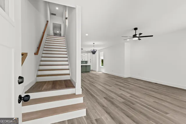 a view of a hallway with wooden floor and staircase