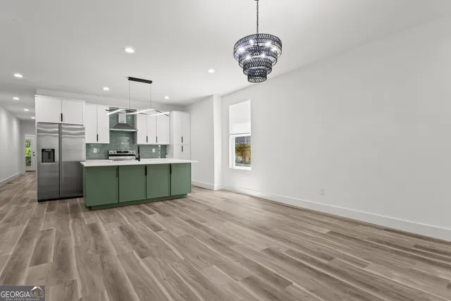 a view of kitchen with granite countertop stainless steel appliances refrigerator and microwave