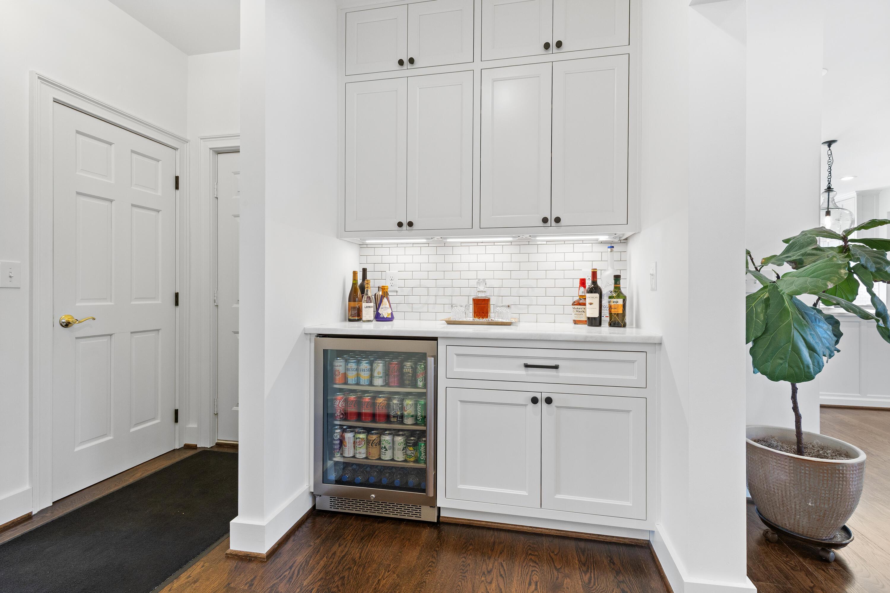 1364 Dale Ford Road Delaware, OH 43015 - Photo 17 of 112 • Hardwood flooring • White painted walls • Custom built wall cabinets • Custom built beverage center • Marble countertop • Ceramic tile backsplash • Soft-close drawers • Under cabinet lighting • Custom built china cabinet