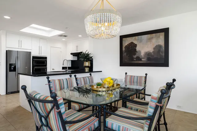 a view of a dining room with furniture a chandelier and wooden floor