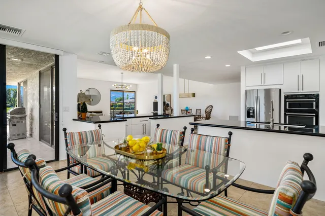 a view of a patio with a table chairs and a small yard