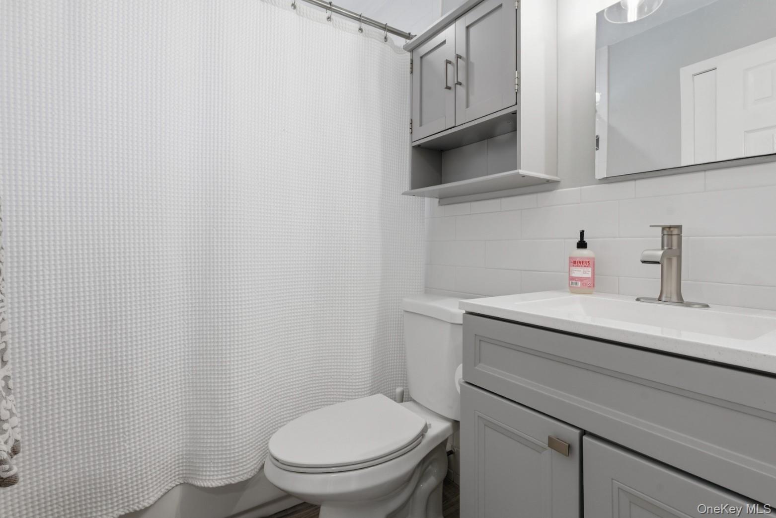 9 Fox Lane Shoreham, NY 11786 - Photo 8 of 13 a bathroom with a sink a toilet and vanity