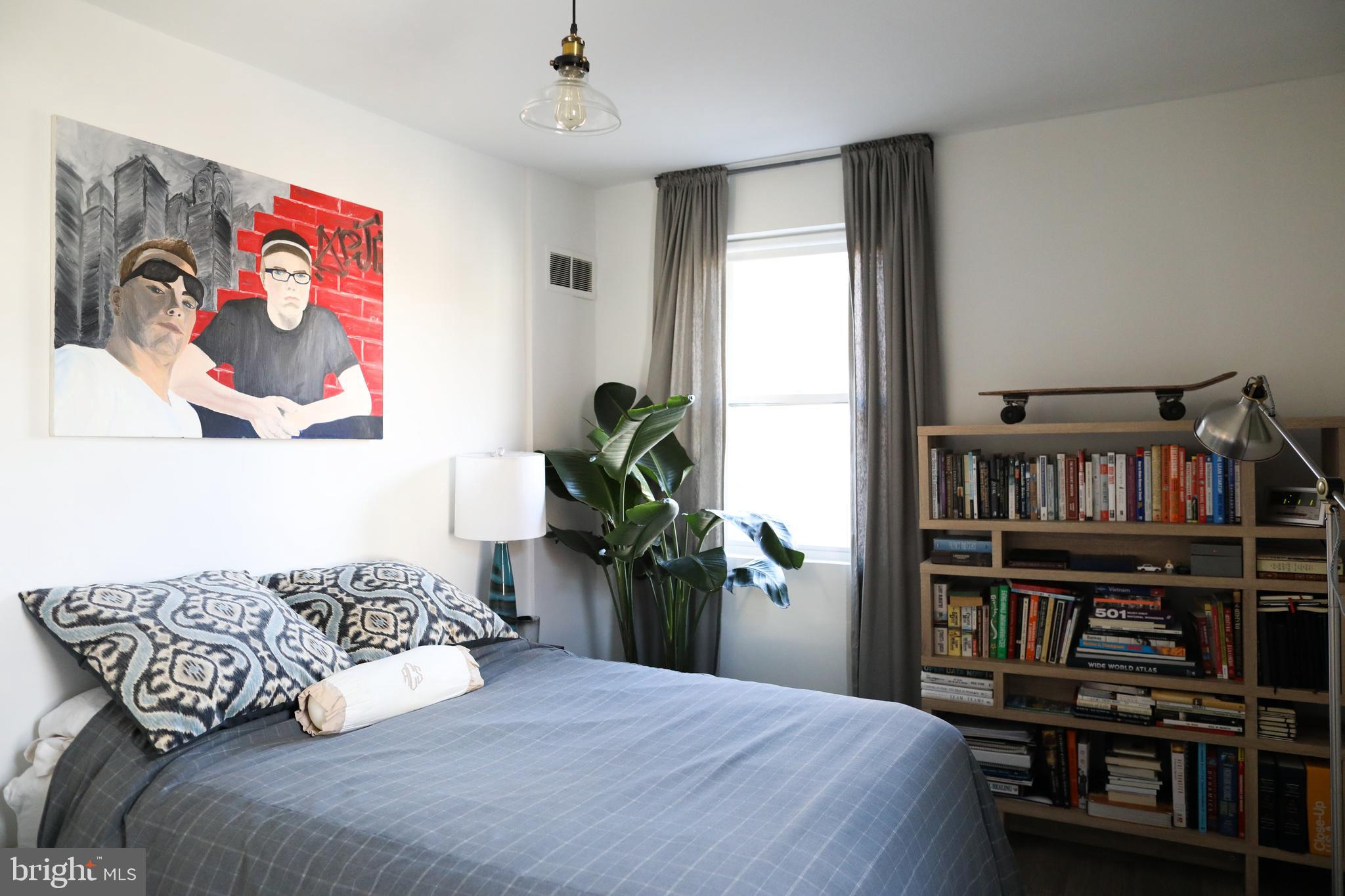 1520-1524 Queen Street Northeast Washington, DC 20002 - Photo 3 of 19 a bedroom with a bed and a book shelf