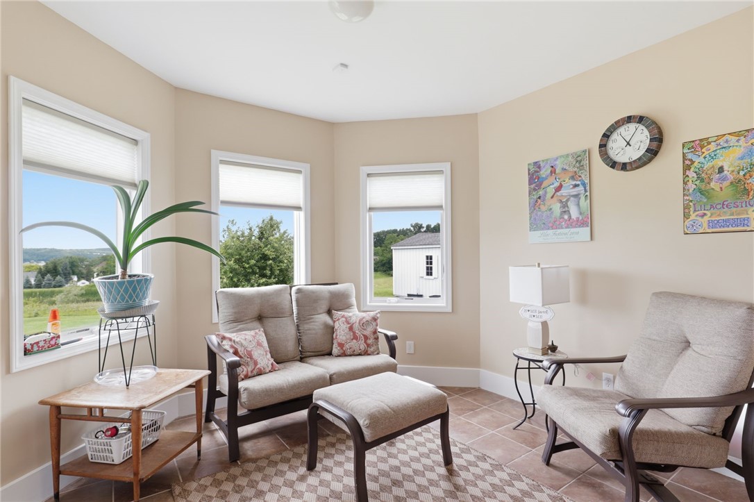 4536 Crystal Ridge Circle Gorham, NY 14424 - Photo 35 of 48 Sunroom on the lower level with windows overlooking the backyard, providing abundant natural light.