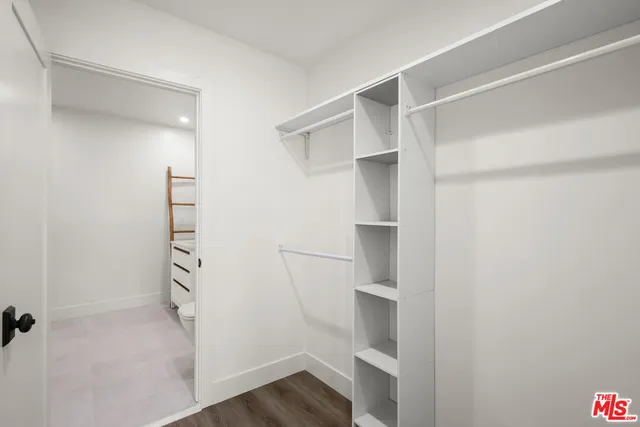 a view of walk in closet with empty racks