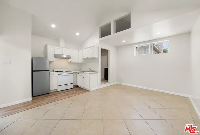 a kitchen with white cabinets a sink appliances and cabinets