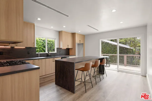 a kitchen with kitchen island a large window in it