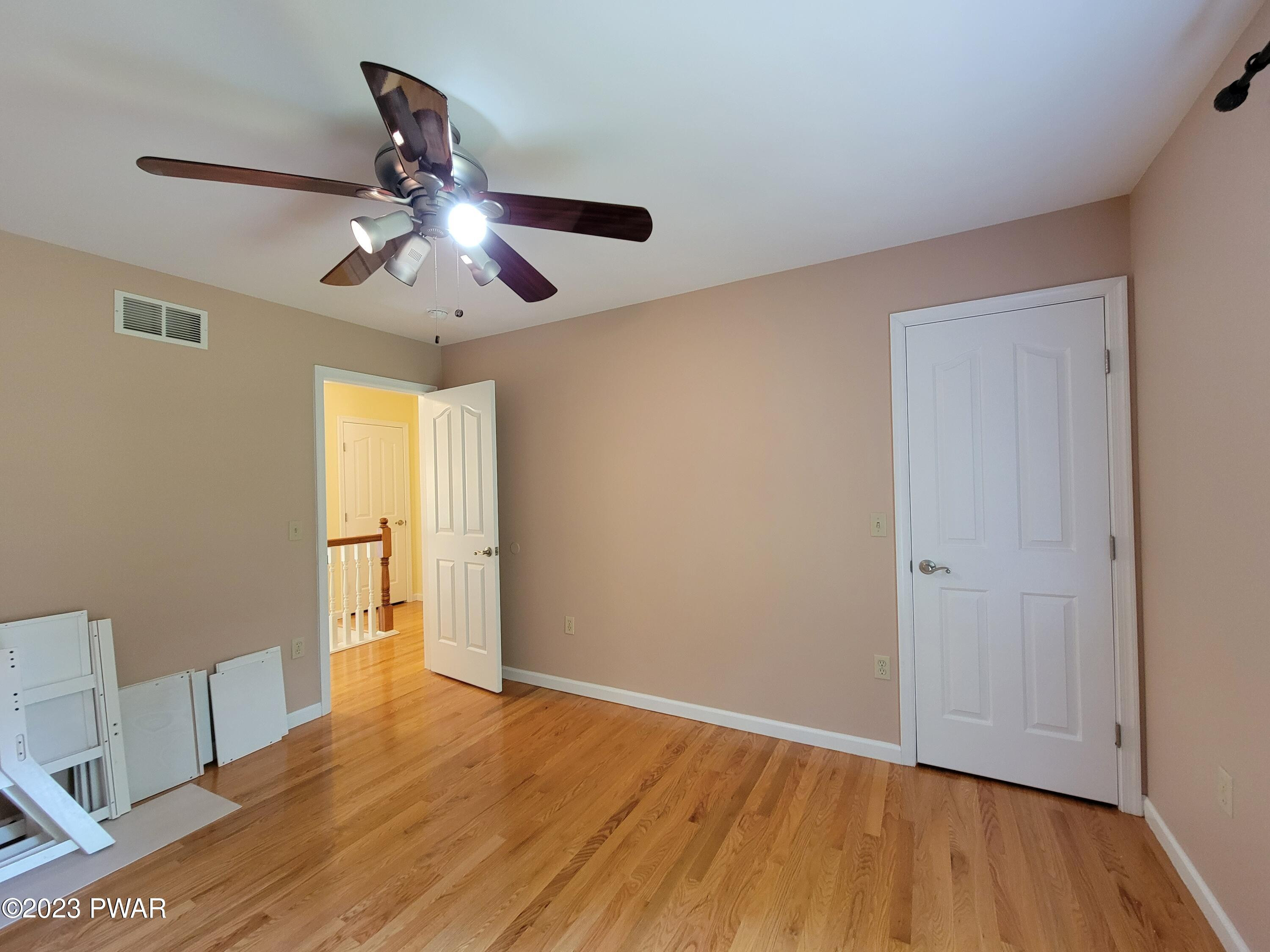 110 Rodeo Lane Hawley, PA 18428 - Photo 29 of 36 a view of empty room with wooden floor and fan