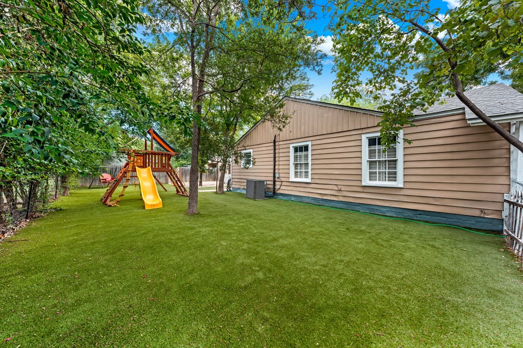 616 Lois Street Kerrville, TX 78028 - Photo 18 of 32 a backyard of a house with plants and large tree
