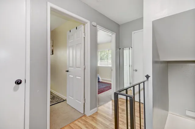 a view of a hallway with wooden floor and staircase