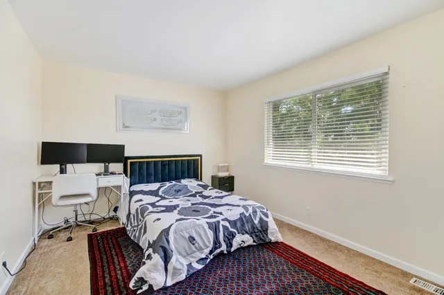 a bed sitting in a bedroom next to a window