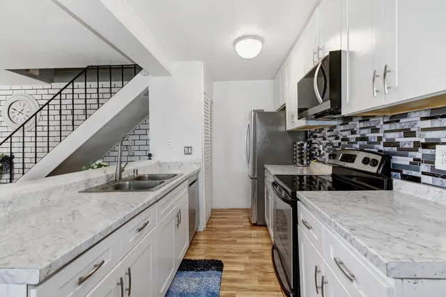a kitchen with stainless steel appliances granite countertop a stove and a refrigerator