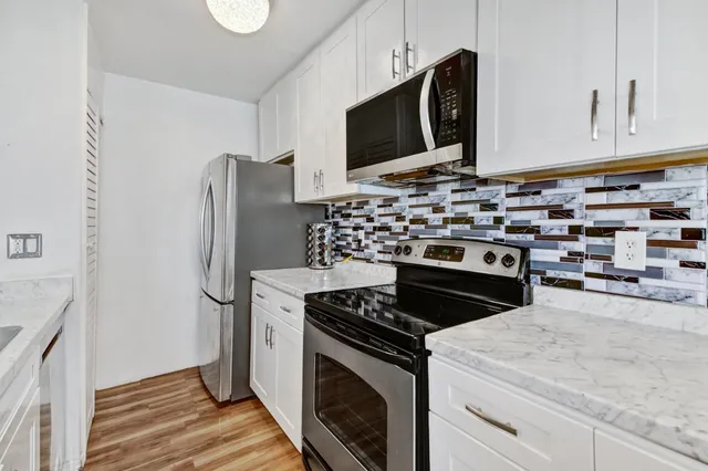 a kitchen with stainless steel appliances a stove microwave and refrigerator