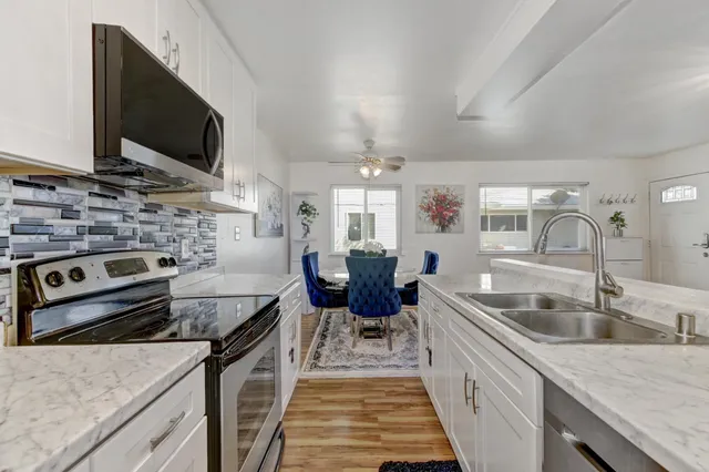 a kitchen with stainless steel appliances granite countertop a sink and a microwave