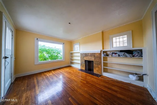 a view of an empty room with a fireplace and a window